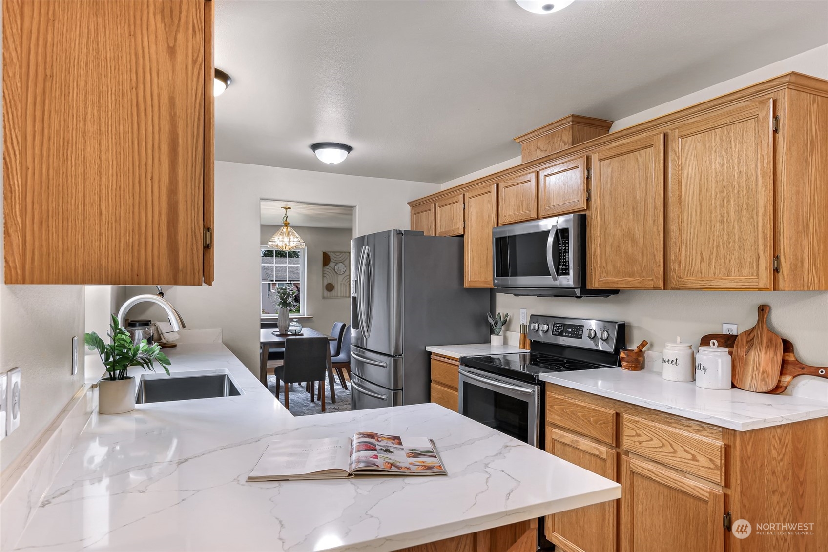14423 Southeast 188 Way Renton, WA 98058 - Photo 13 of 40 a kitchen with stainless steel appliances granite countertop a refrigerator a sink dishwasher a stove and a dining table with wooden cabinet