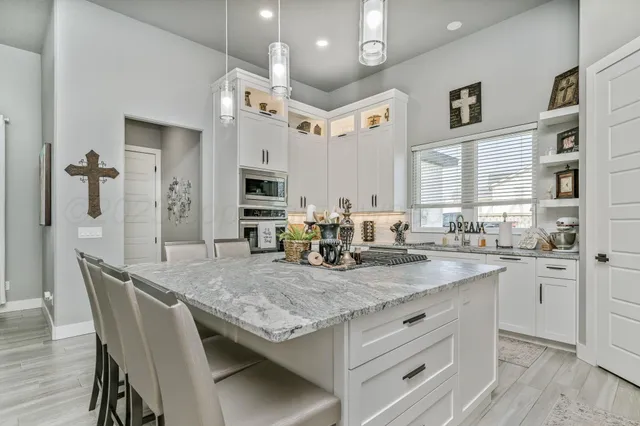 a kitchen with stainless steel appliances granite countertop a sink a stove and a refrigerator