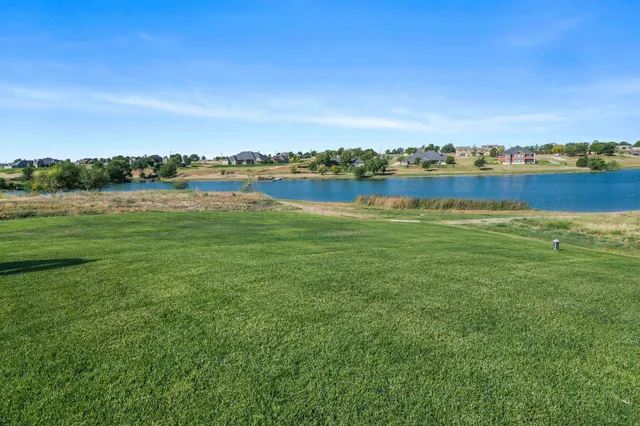an aerial view of a house with outdoor space and lake view in back