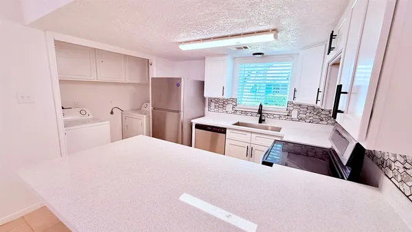 a kitchen with a sink a counter top space and stainless steel appliances