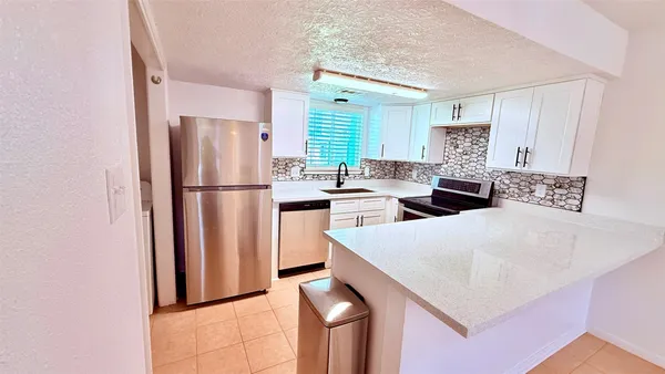a kitchen with stainless steel appliances a refrigerator a stove a sink and a refrigerator