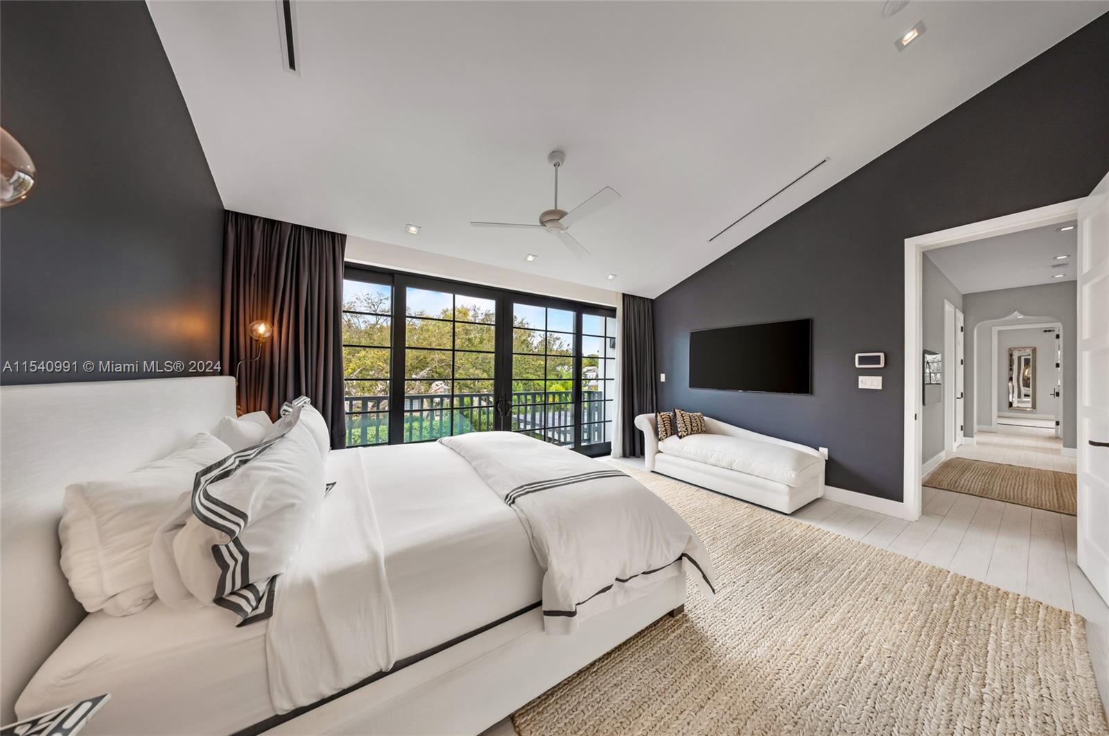 590 Northeast 59th Street Miami, FL 33137 - Photo 18 of 32 a bedroom with a large bed and a flat screen tv