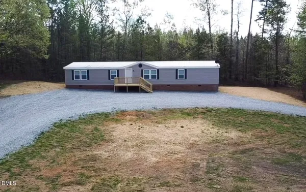 a view of a house with a yard and sitting area