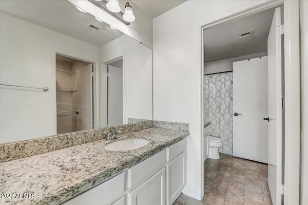 a bathroom with a granite countertop sink and a mirror