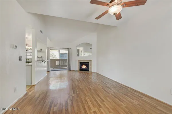 a view of a livingroom with wooden floor a fireplace and windows
