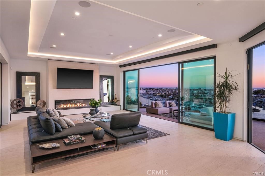 1207 Dolphin Terrace Corona del Mar, CA 92625 - Photo 12 of 58 a living room with furniture a flat screen tv and floor to ceiling window