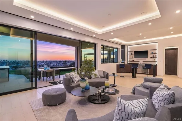 a living room with furniture flat screen tv and a floor to ceiling window