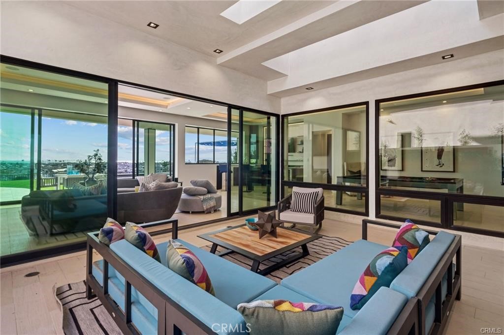 1207 Dolphin Terrace Corona del Mar, CA 92625 - Photo 15 of 58 a living room with furniture flat screen tv and a floor to ceiling window