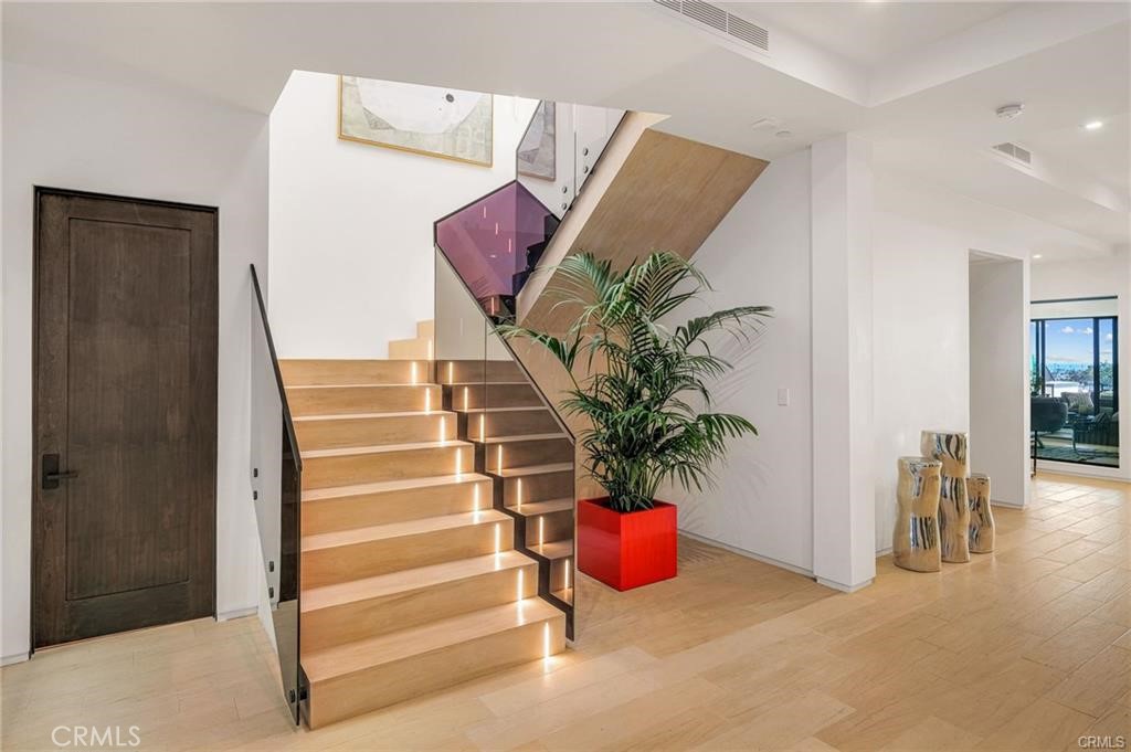 1207 Dolphin Terrace Corona del Mar, CA 92625 - Photo 19 of 58 a view of an entryway with wooden floor and a potted plant