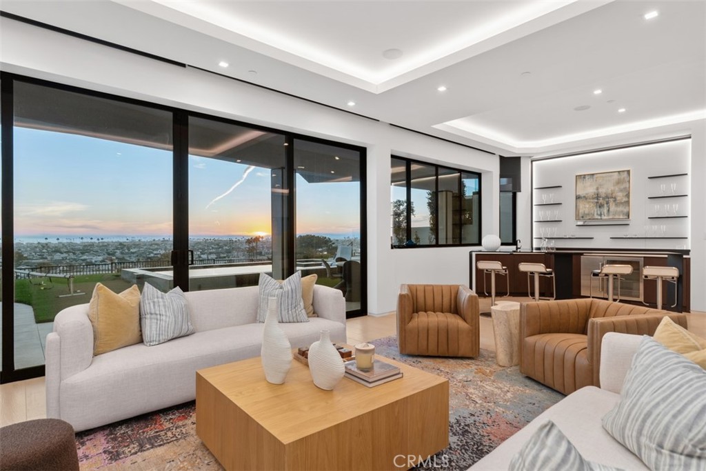1207 Dolphin Terrace Corona del Mar, CA 92625 - Photo 32 of 58 a living room with furniture large windows and a flat screen tv