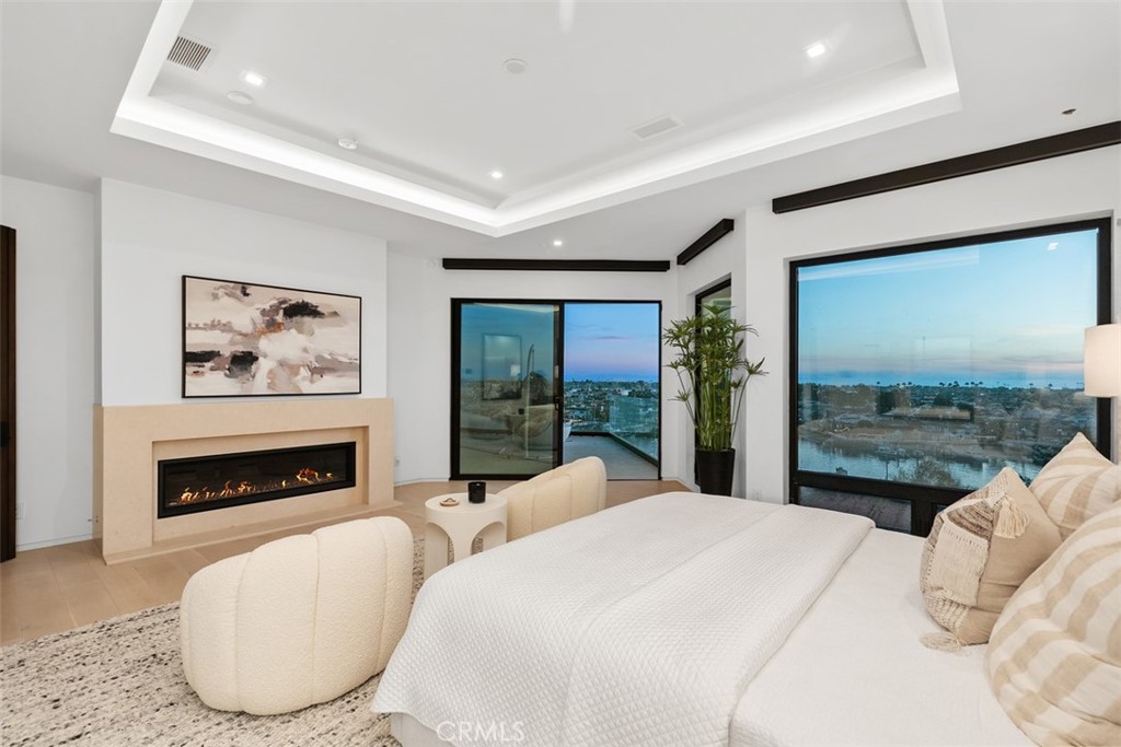 1207 Dolphin Terrace Corona del Mar, CA 92625 - Photo 41 of 58 a bedroom with a large bed and a fireplace