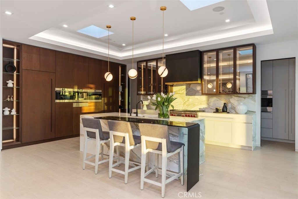 1207 Dolphin Terrace Corona del Mar, CA 92625 - Photo 54 of 58 a kitchen with stainless steel appliances kitchen island granite countertop a table and chairs in it