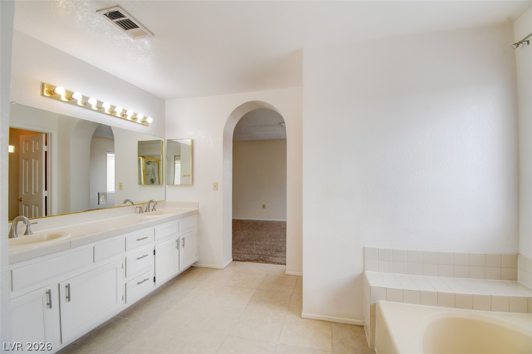 5 Tarryall Terrace Henderson, NV 89074 - Photo 36 of 44 Dual vanities and an arched entryway enhance this spacious bathroom.