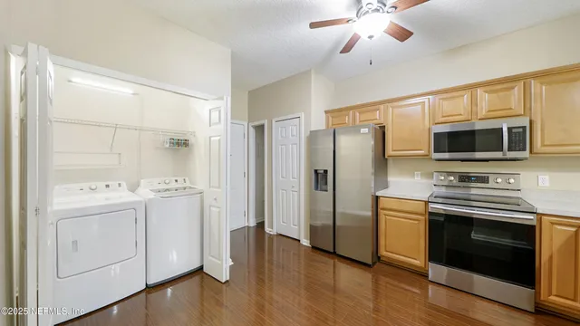 a kitchen with stainless steel appliances a stove microwave and refrigerator
