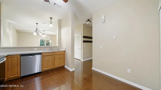 a kitchen with stainless steel appliances a refrigerator and a hard wood floor