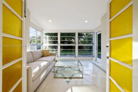 a living room with a blue floor to ceiling windows and a table
