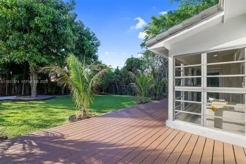 a front view of a house with a garden and trees