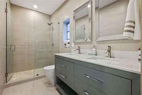 a en suite bathroom with a granite countertop sink and a mirror