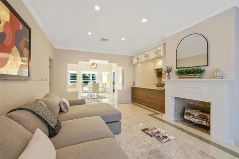 a living room with furniture a fireplace and a floor to ceiling window