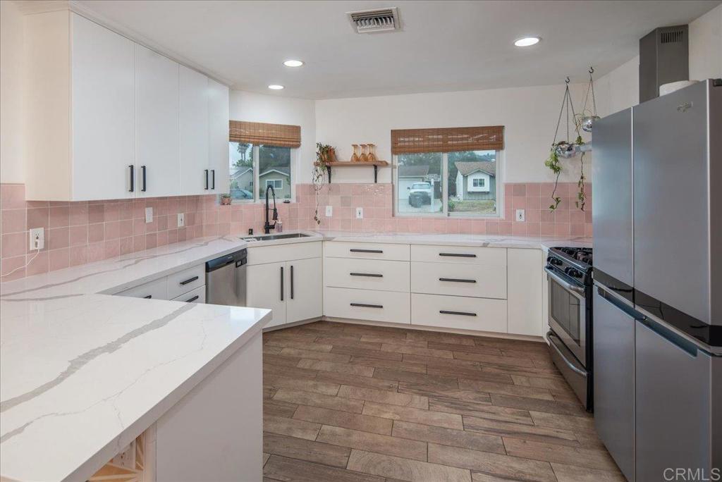 14539 Kennebunk Street Poway, CA 92064 - Photo 7 of 26 a kitchen with stainless steel appliances a refrigerator sink and cabinets