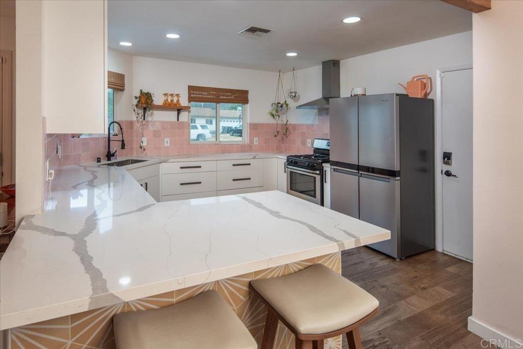 14539 Kennebunk Street Poway, CA 92064 - Photo 10 of 26 a kitchen with stainless steel appliances a refrigerator sink and stove