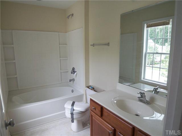 2713 Andover Glen Road Raleigh, NC 27604 - Photo 7 of 11 a bathroom with a granite countertop sink a toilet and bathtub