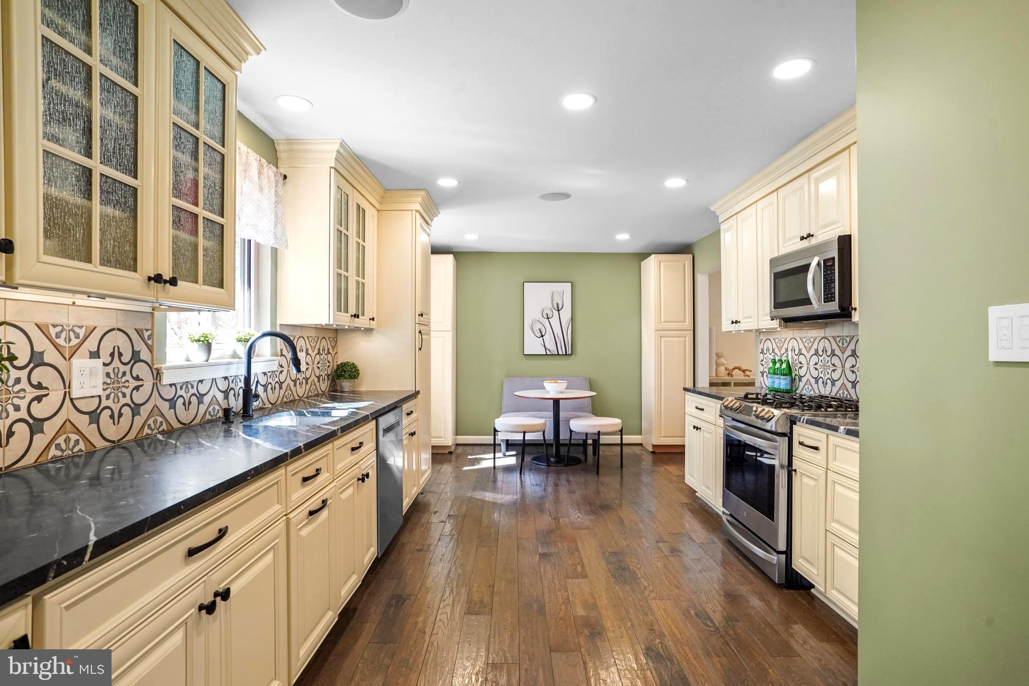 9036 Brook Ford Road Burke, VA 22015 - Photo 9 of 40 a large kitchen with stainless steel appliances granite countertop a lot of counter space and wooden floors