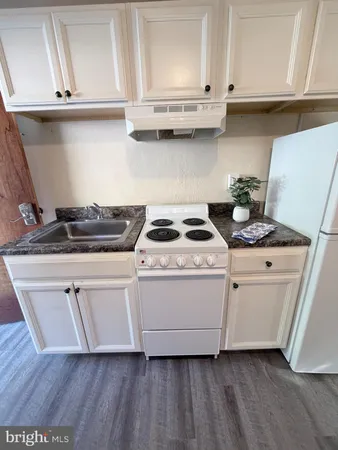 a kitchen with granite countertop white cabinets and white appliances