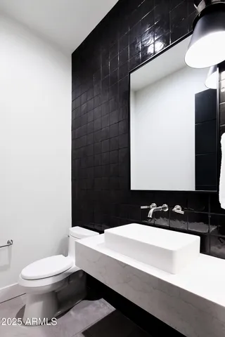 a bathroom with a sink a toilet and mirror