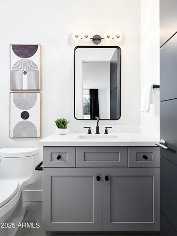 a bathroom with a toilet sink and mirror