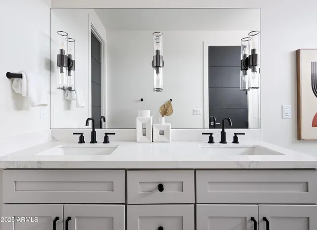 a bathroom with double vanity sinks and a mirror