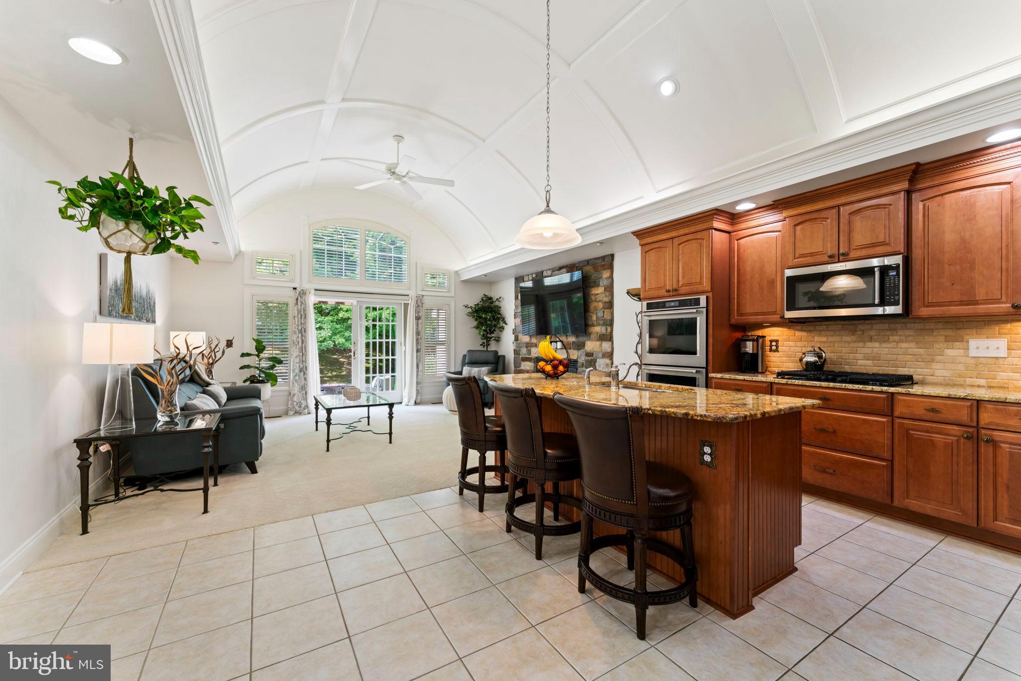 2411 Grand Oaks Court, Unit 30 Abingdon, MD 21009 - Photo 9 of 45 a kitchen with stainless steel appliances granite countertop a sink a stove a dining table and chairs with wooden floor