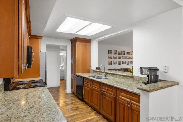 a kitchen with a granite countertop sink stove and refrigerator
