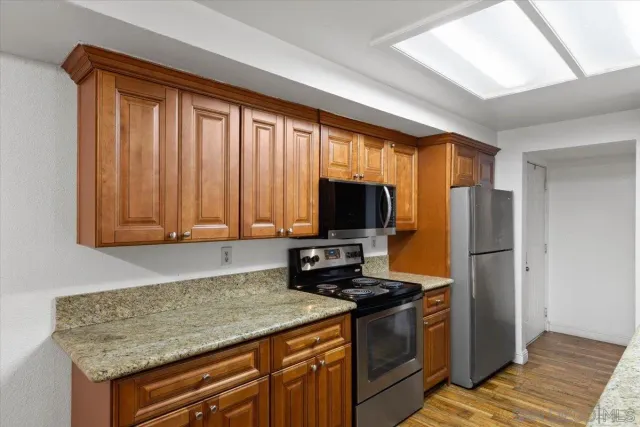 a kitchen with stainless steel appliances granite countertop a refrigerator stove and microwave