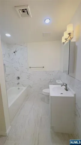 a bathroom with a sink a toilet and bathtub