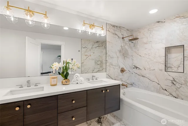 a bathroom with a tub double sink shower and mirror