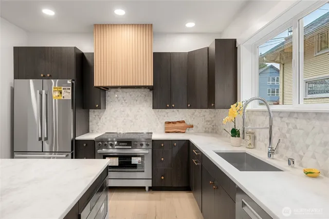 a kitchen with stainless steel appliances a sink stove and refrigerator
