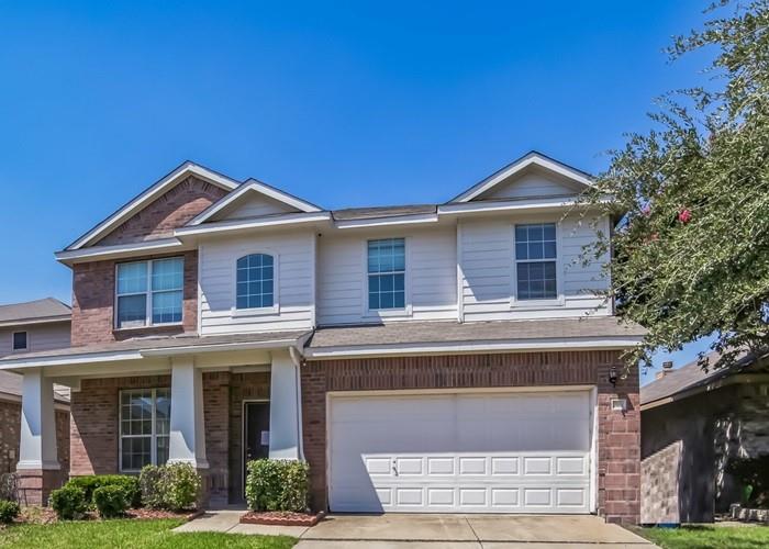 View of front of home featuring brick siding, driveway, a garage, and a porch