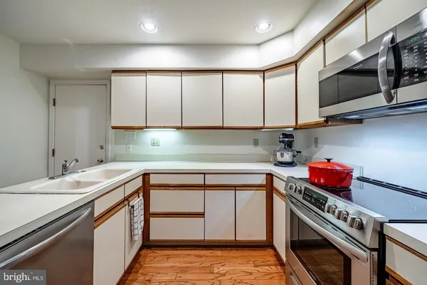 a kitchen with stainless steel appliances a sink a stove and cabinets