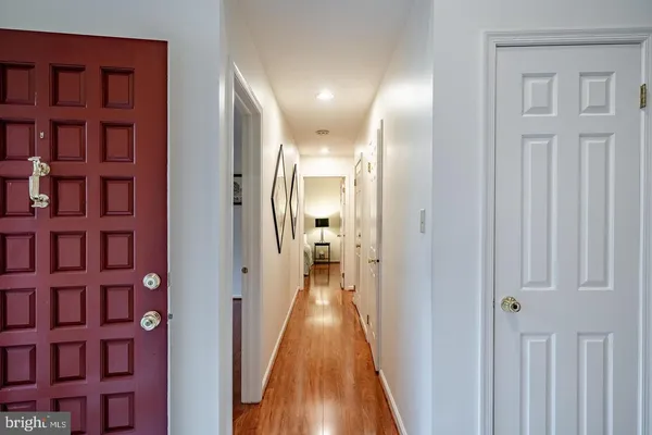 a view of a hallway with wooden floor and a bookshelf