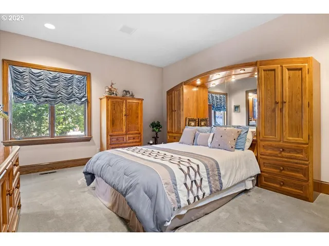 a bedroom with furniture and large window