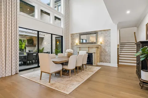 a kitchen with stainless steel appliances granite countertop a stove a sink and white cabinets with wooden floor