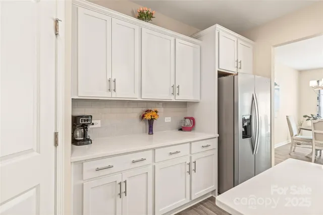 a kitchen with stainless steel appliances white cabinets and a refrigerator