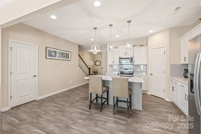 a kitchen with a dining table chairs refrigerator and cabinets
