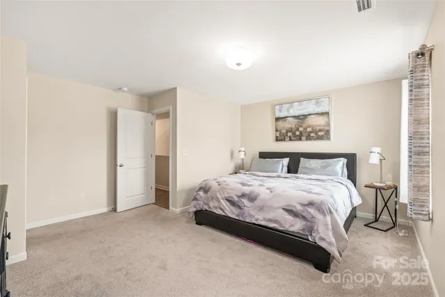 a bedroom with a bed and a painting on the wall