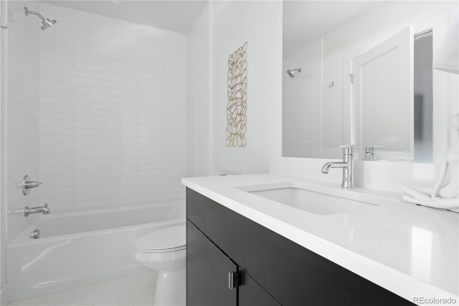 1686 Tabor Street Lakewood, CO 80215 - Photo 17 of 34 a bathroom with a sink a toilet and shower