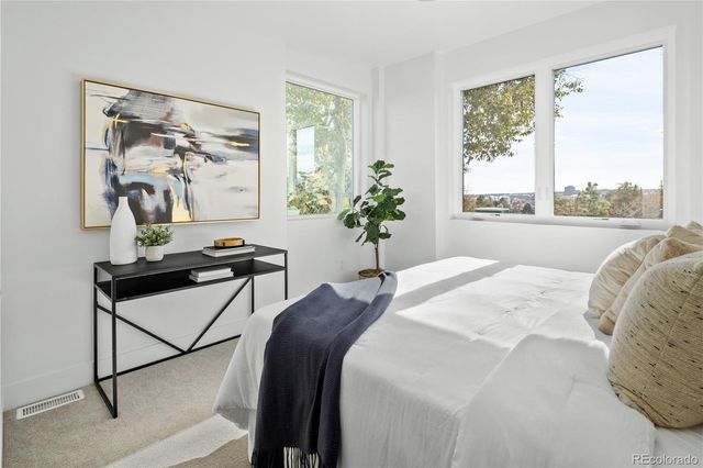 a bed sitting in a bedroom next to a window