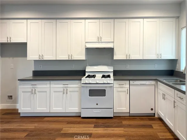 a kitchen with white cabinets and white appliances