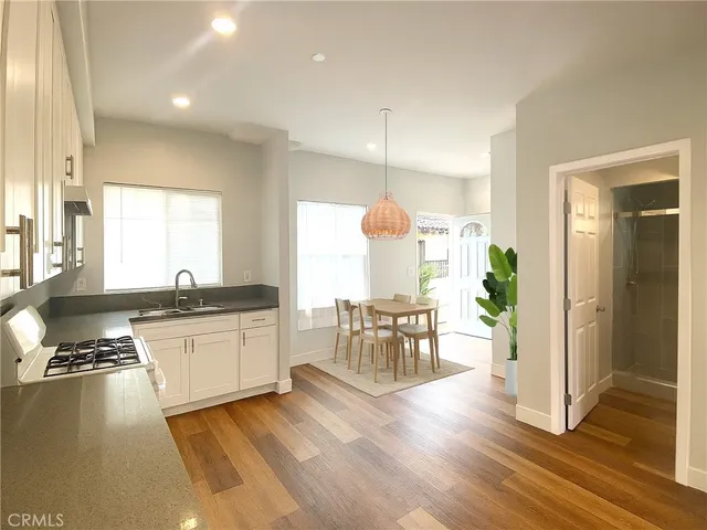 a kitchen with granite countertop a stove a sink and a refrigerator