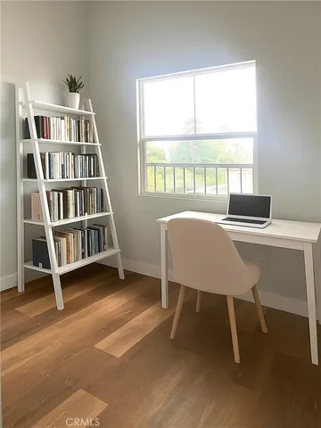 a view of a workspace with furniture and a window